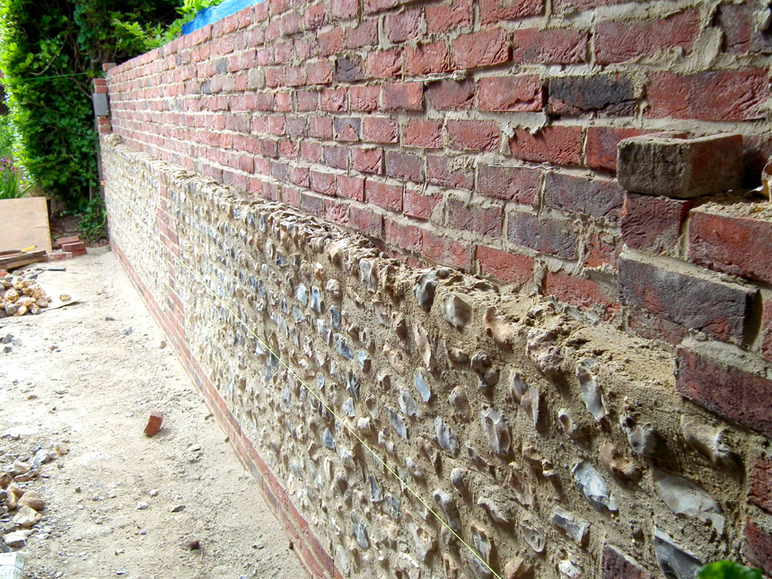 A flint wall being built